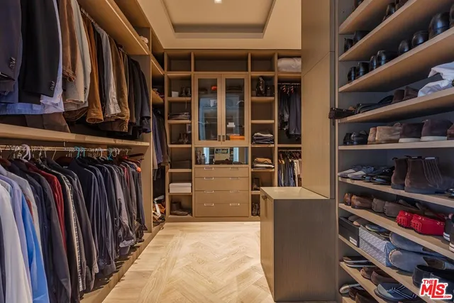 a view of walk in closet with clothes and shoes
