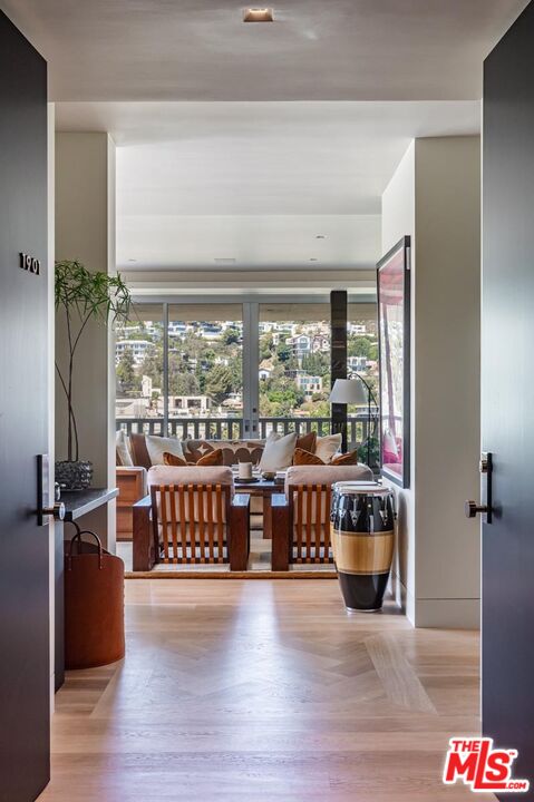 9255 Doheny Road, Unit 1901 West Hollywood, CA 90069 - Photo 2 of 23 a living room with stainless steel appliances furniture wooden floor and a large window