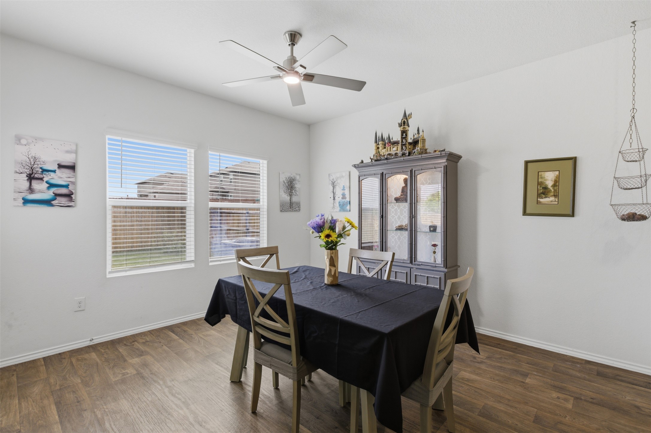 19017 Romano Drive Elgin, TX 78621 - Photo 11 of 33 Dining area featuring wood-finish flooring, two window openings, and a ceiling fan with integrated lighting