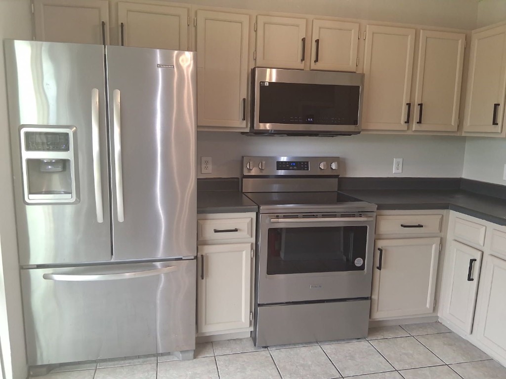 7704 Sign Street Houston, TX 77489 - Photo 5 of 27 a kitchen with stainless steel appliances a refrigerator stove and microwave