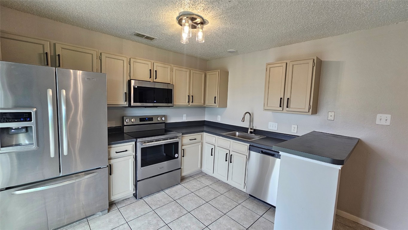 7704 Sign Street Houston, TX 77489 - Photo 6 of 27 a kitchen with granite countertop a refrigerator stove and microwave