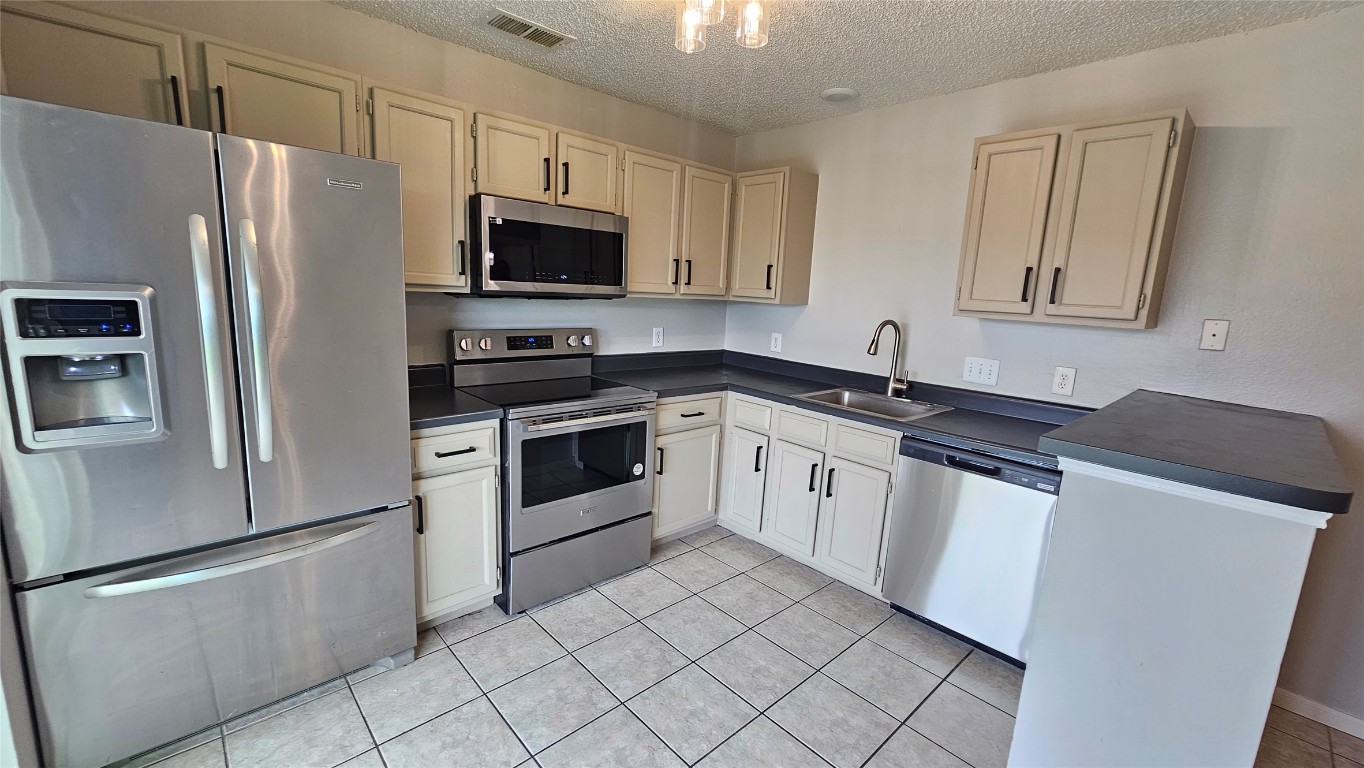 7704 Sign Street Houston, TX 77489 - Photo 10 of 27 a white kitchen with granite countertop stainless steel appliances and a sink