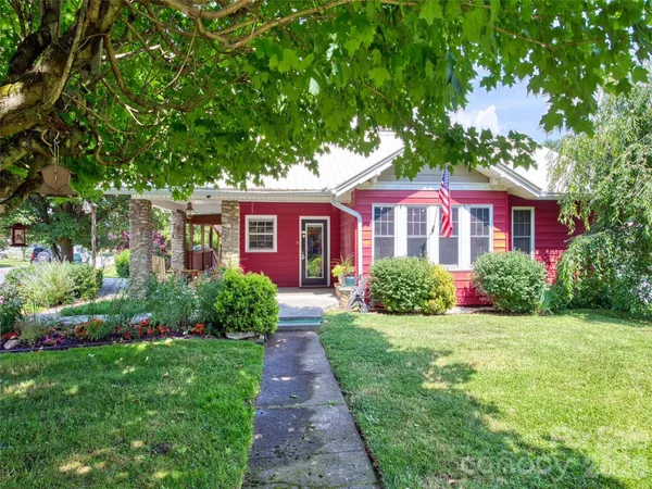 a front view of a house with a yard and green space