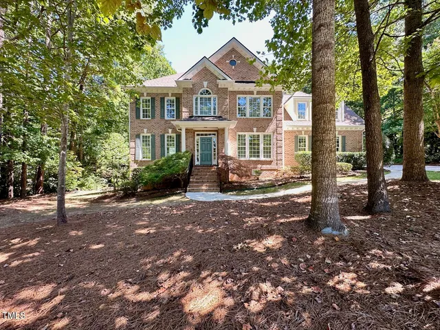a front view of a house with a yard and tree s