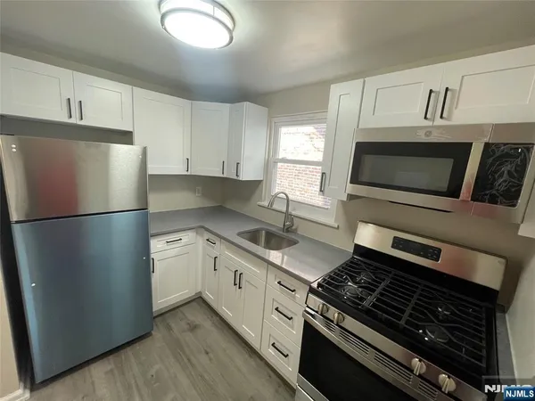 a kitchen with stainless steel appliances granite countertop a stove a refrigerator and a microwave