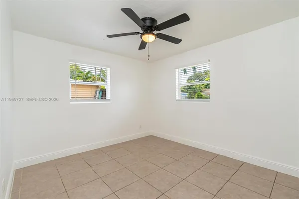 an empty room with window and ceiling fan