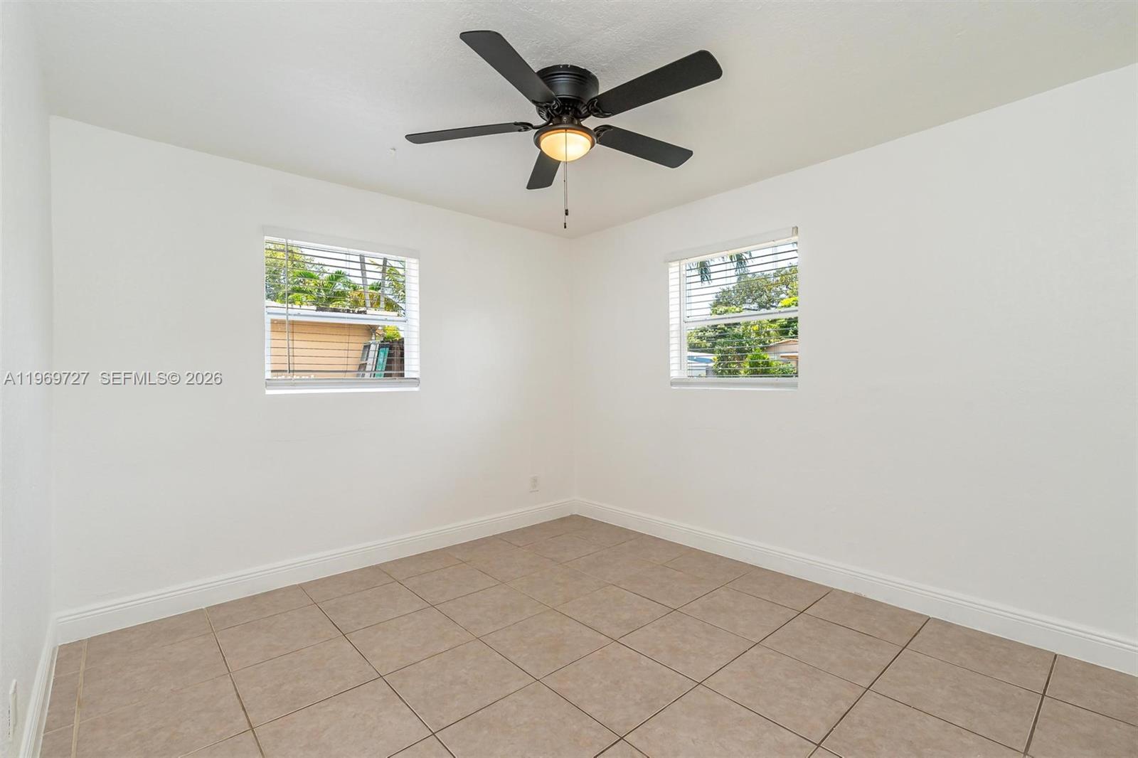5615 Simms Street Hollywood, FL 33021 - Photo 11 of 27 an empty room with window and ceiling fan