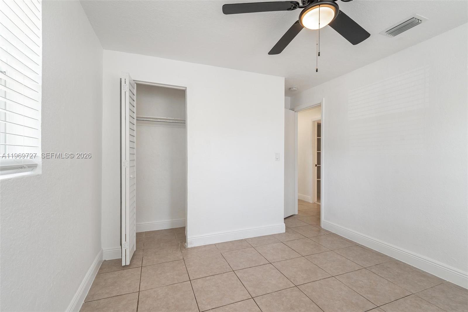 5615 Simms Street Hollywood, FL 33021 - Photo 12 of 27 an empty room with closet and a chandelier fan