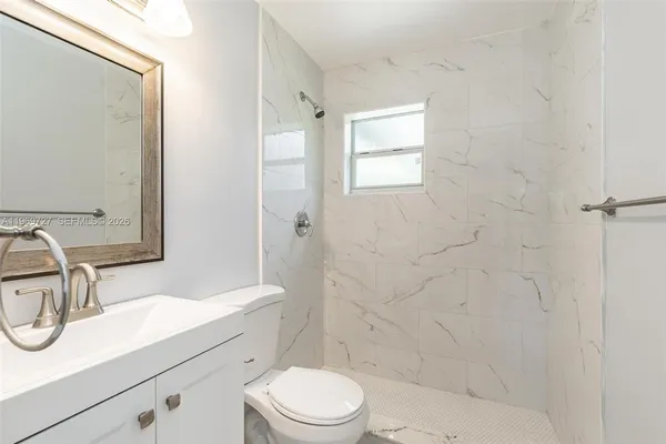 a bathroom with a sink a toilet and shower