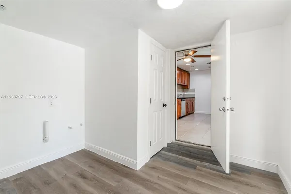 an empty room with a window and a fan