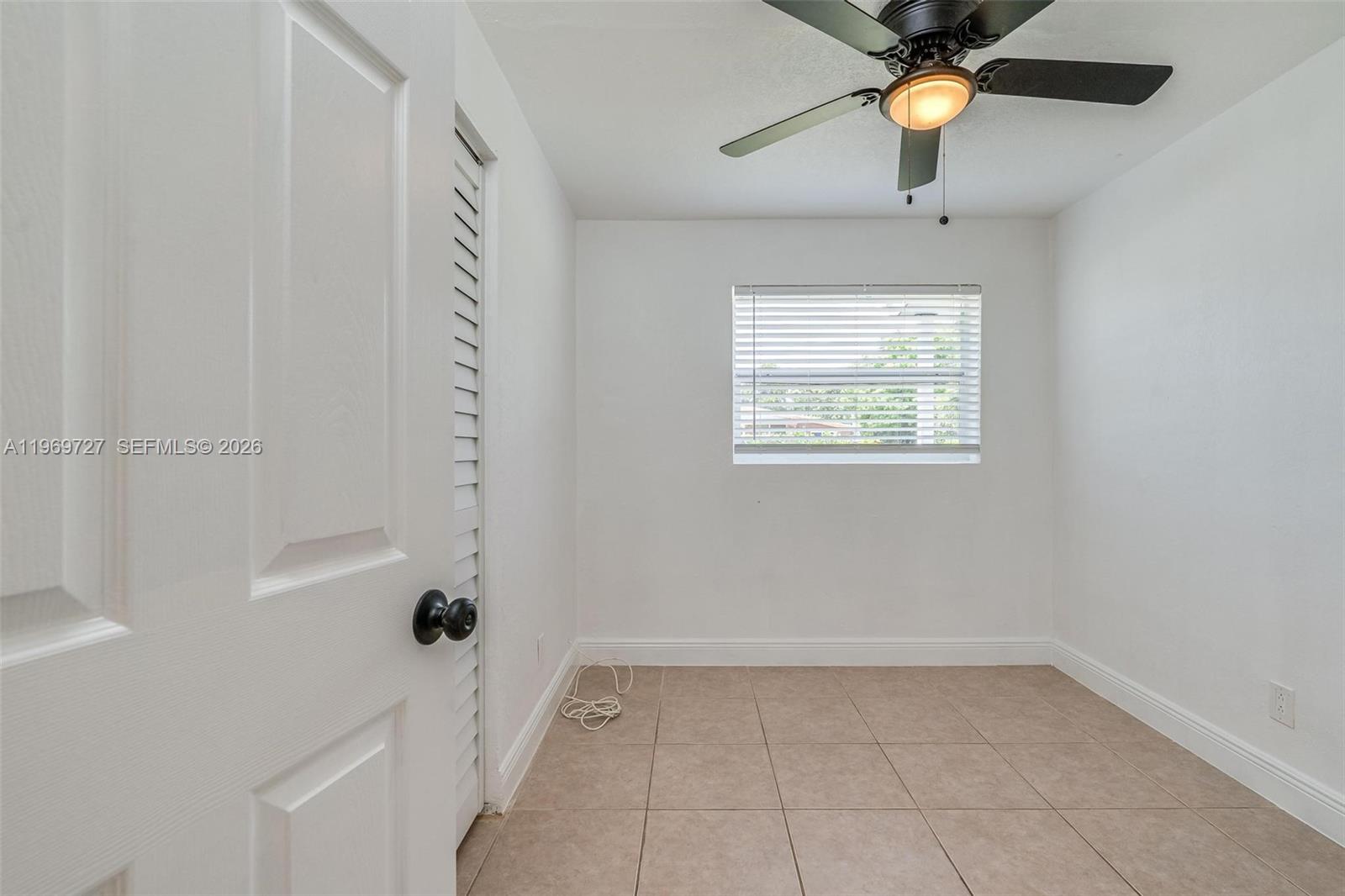 5615 Simms Street Hollywood, FL 33021 - Photo 22 of 27 an empty room with a window and a fan