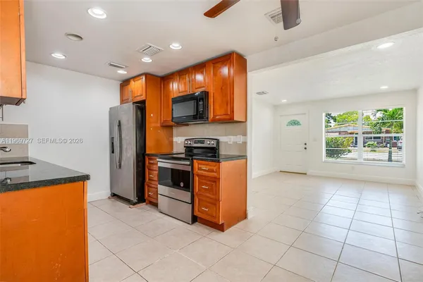 a kitchen with stainless steel appliances granite countertop a refrigerator and a stove