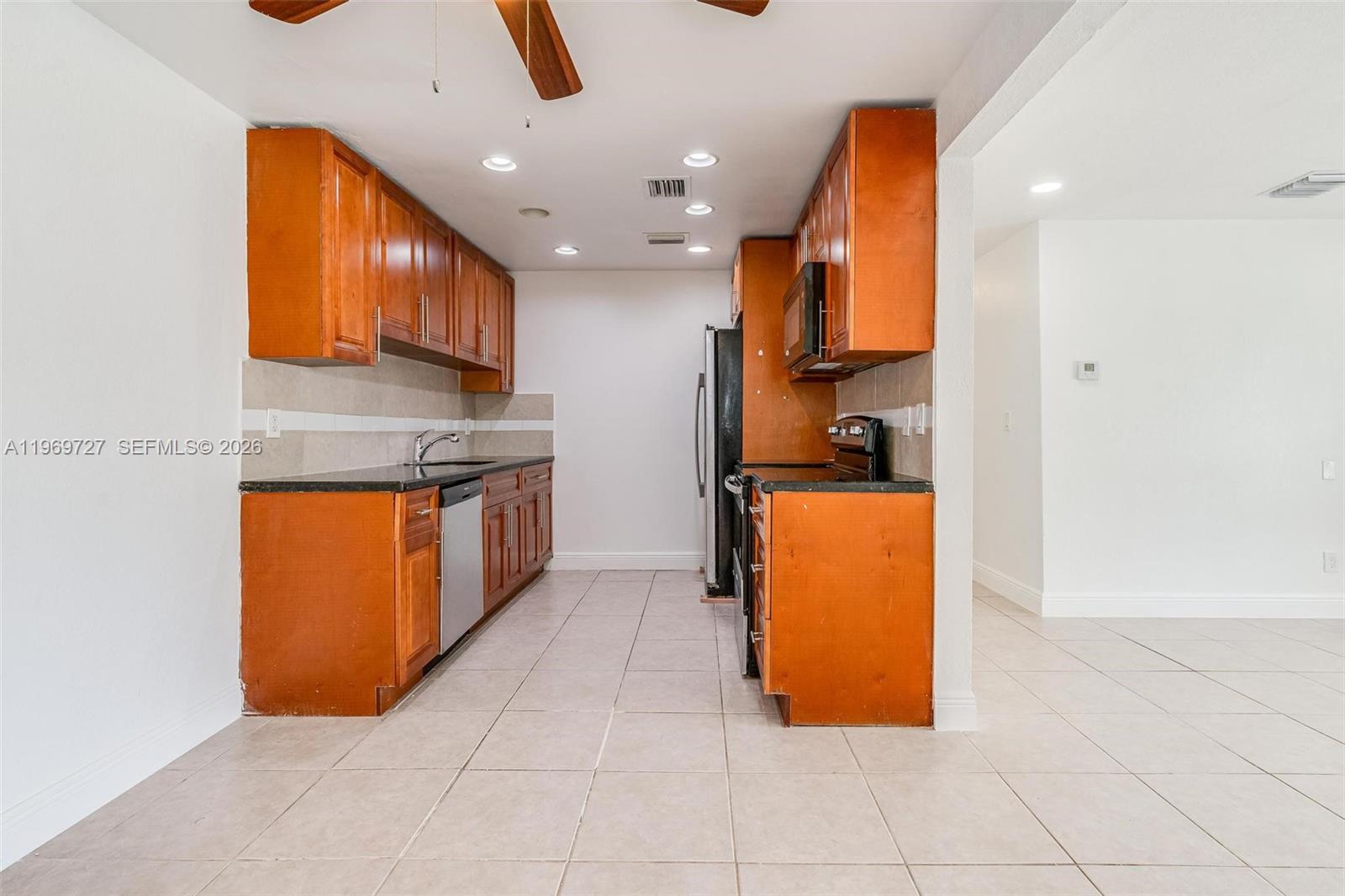 5615 Simms Street Hollywood, FL 33021 - Photo 25 of 27 a kitchen with stainless steel appliances granite countertop a refrigerator and a stove