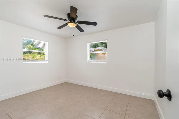 an empty room with a window and a ceiling fan