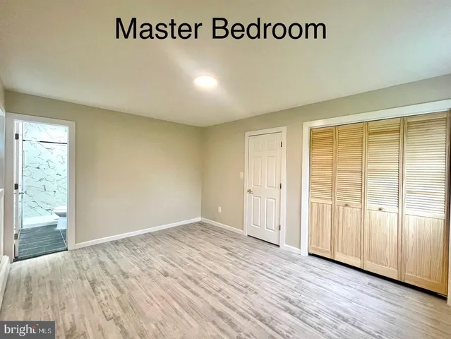 an empty room with wooden floor and sliding door