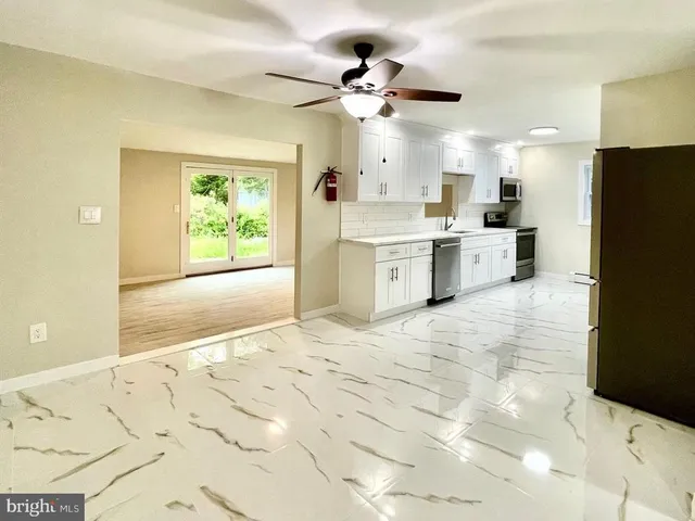 a view of a kitchen with a sink and refrigerator