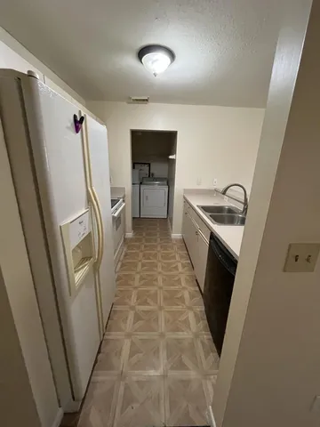 a kitchen with a sink a refrigerator a washer and dryer