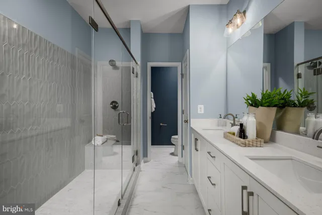 a spacious bathroom with a granite countertop sink mirror and shower