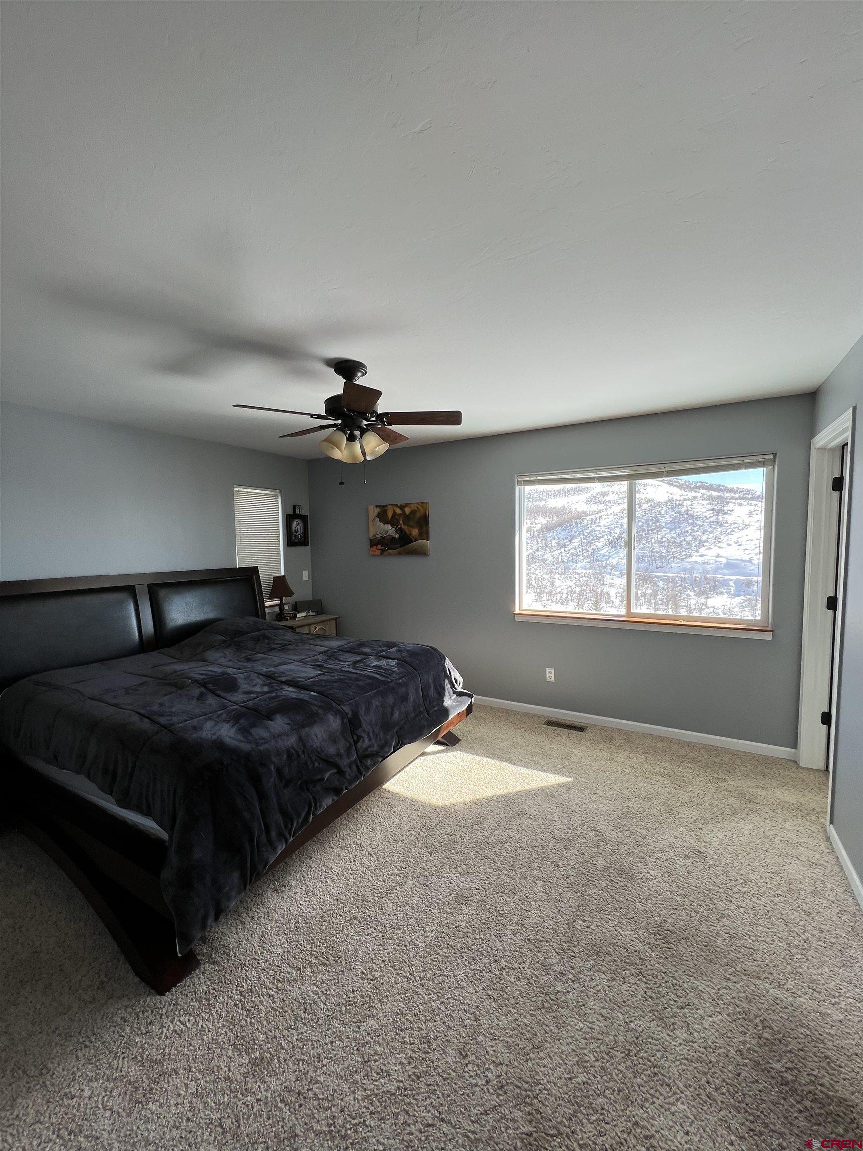 22350 Surface Creek Road Cedaredge, CO 81413 - Photo 16 of 32 a bedroom with a bed and a window