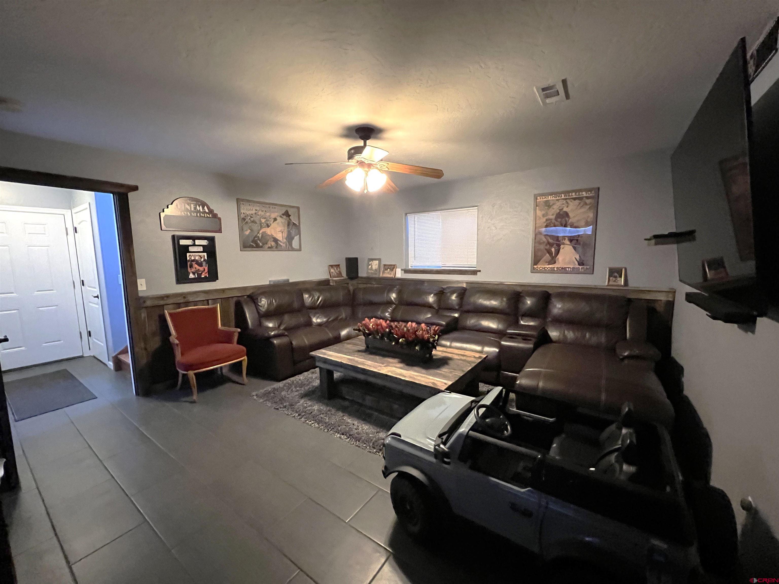 22350 Surface Creek Road Cedaredge, CO 81413 - Photo 22 of 32 a living room with furniture a flat screen tv and a fireplace
