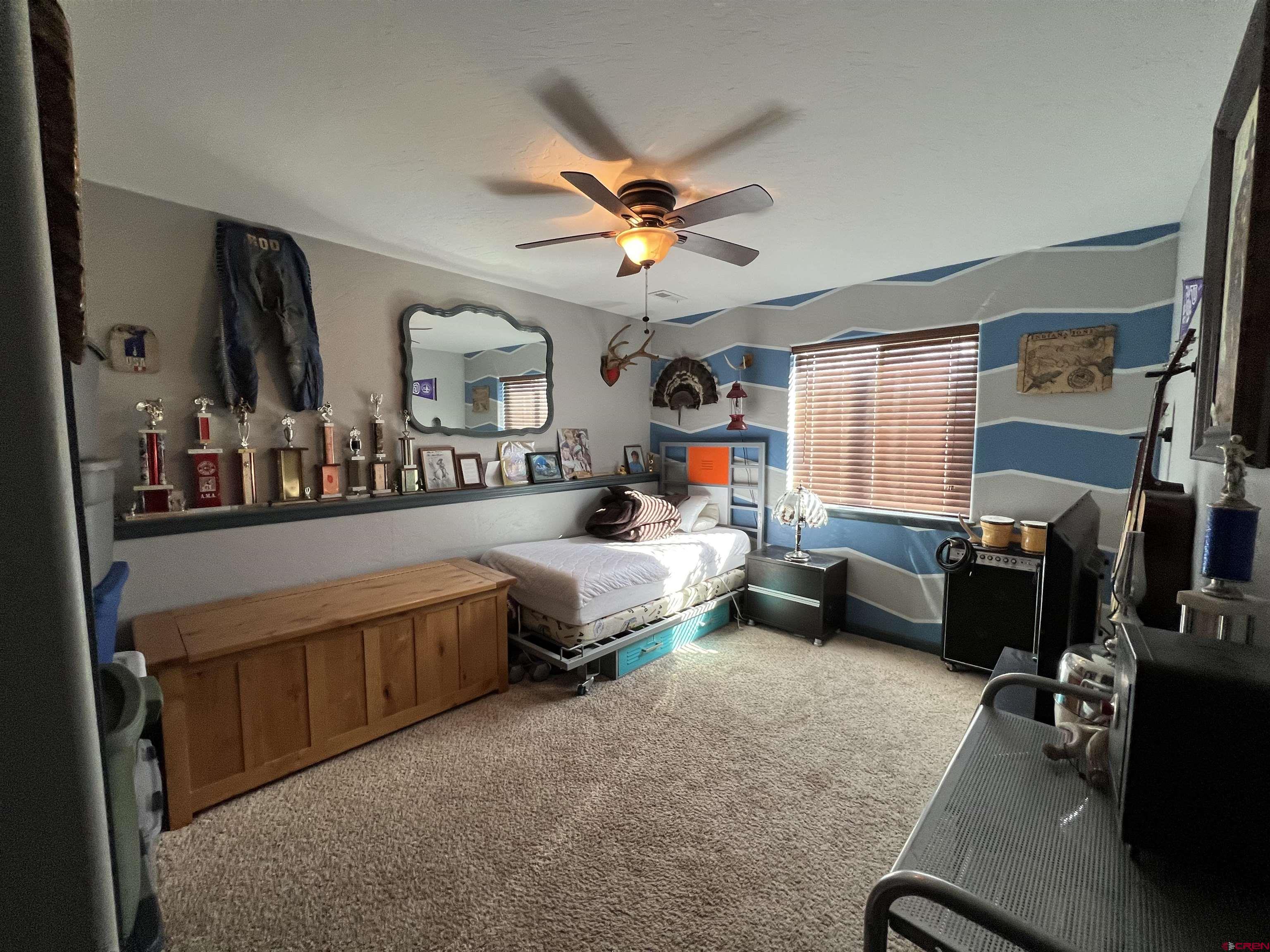 22350 Surface Creek Road Cedaredge, CO 81413 - Photo 27 of 32 a bedroom with a bed gym equipment and a window