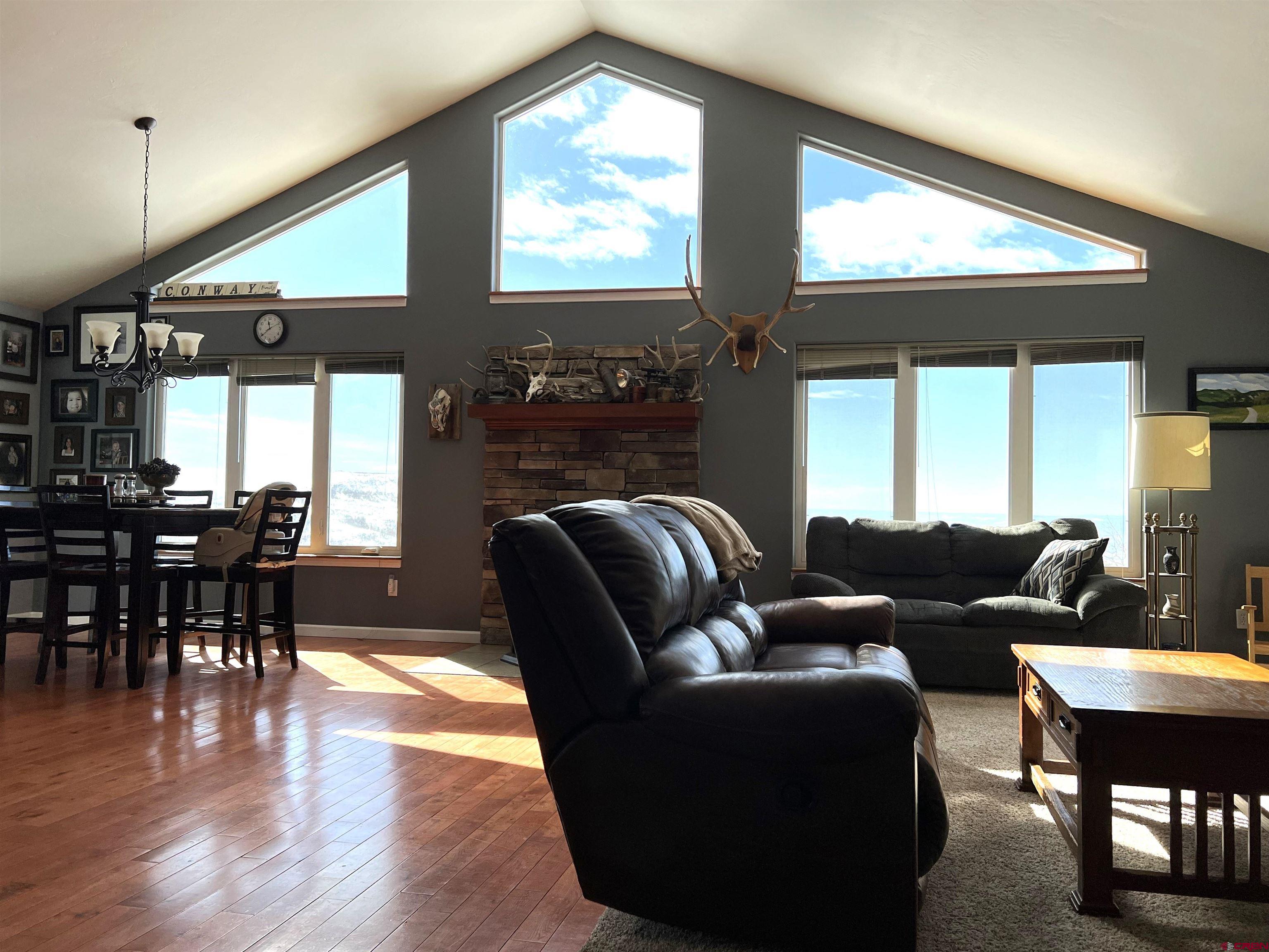 22350 Surface Creek Road Cedaredge, CO 81413 - Photo 28 of 32 a living room with furniture a large window and wooden floor