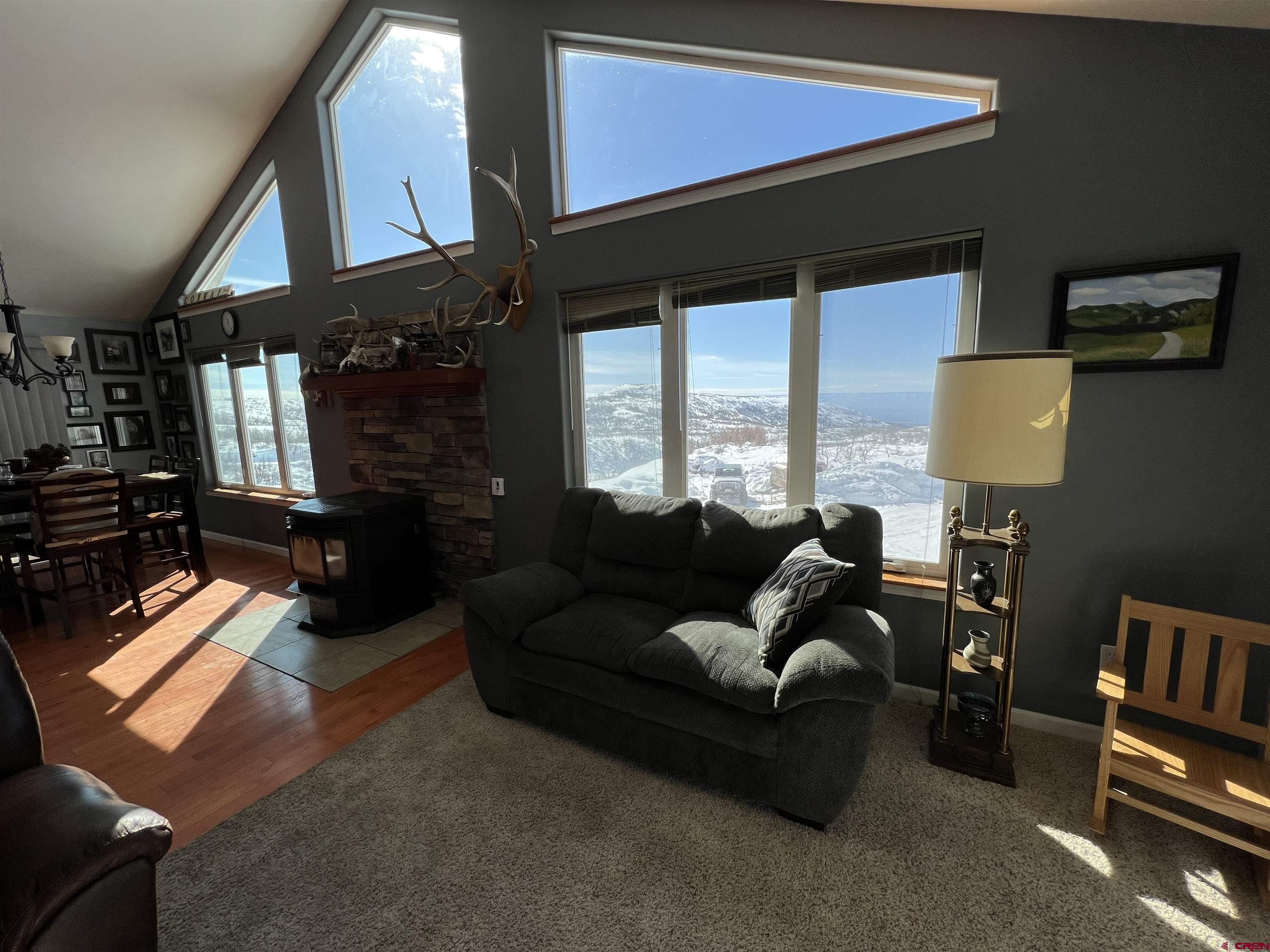 22350 Surface Creek Road Cedaredge, CO 81413 - Photo 9 of 32 a living room with furniture fireplace and a window