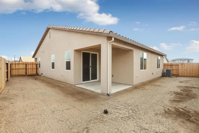 a view of a house with backyard and utility room