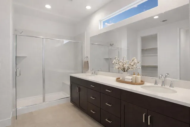 a bathroom with double sink and a mirror