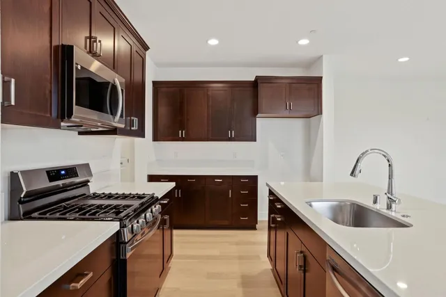 a kitchen with stainless steel appliances a sink stove and microwave