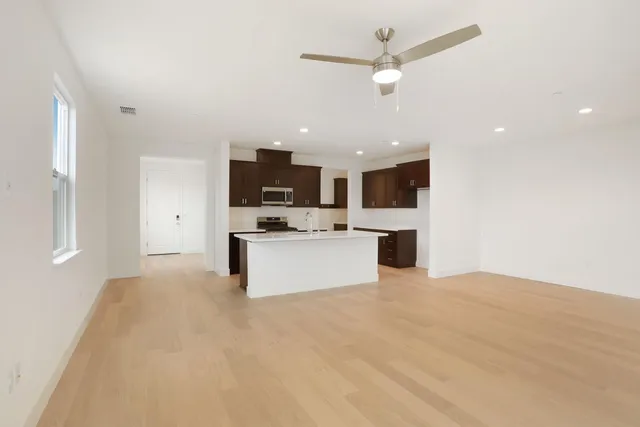 a view of kitchen with kitchen island a sink stainless steel appliances and cabinets