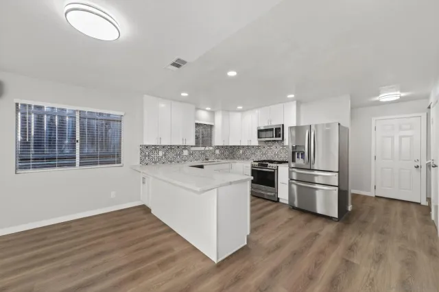a large white kitchen with a white countertops and cabinets