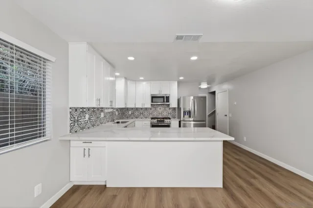 a kitchen with stainless steel appliances granite countertop a stove and a sink