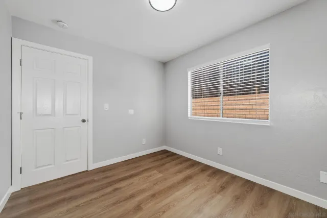 a view of a big room with wooden floor and windows