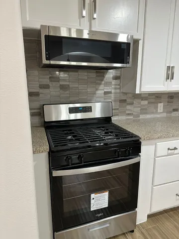 a stove top oven sitting inside of a kitchen