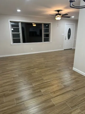 a view of an empty room with wooden floor