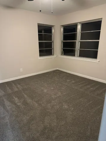 a view of an empty room with a window and fireplace