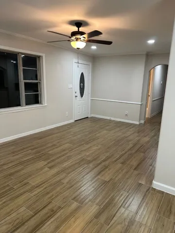 a view of an empty room with a window and wooden floor