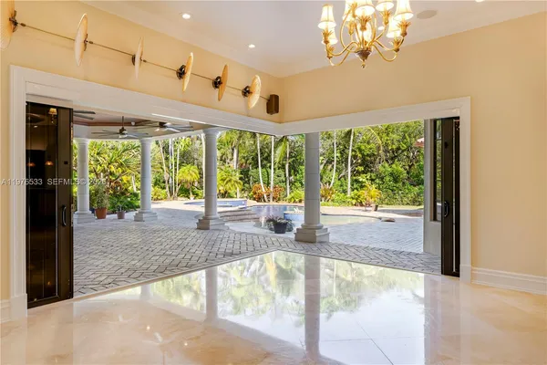 a view of a kitchen with kitchen island a sink a counter top space and stainless steel appliances