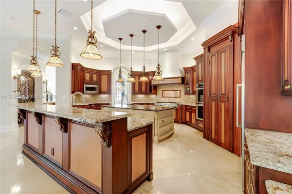a kitchen with stainless steel appliances granite countertop a stove and a chandelier