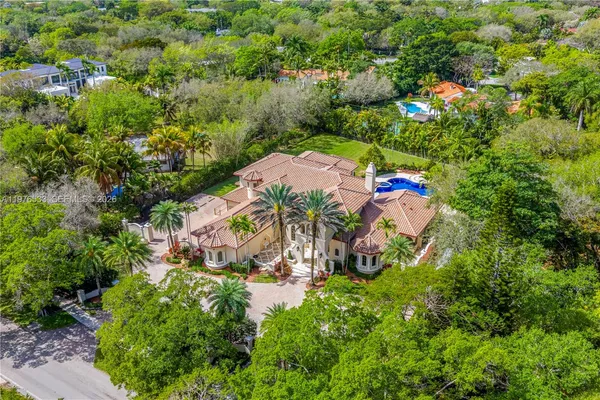 an aerial view of residential house with outdoor space and trees all around
