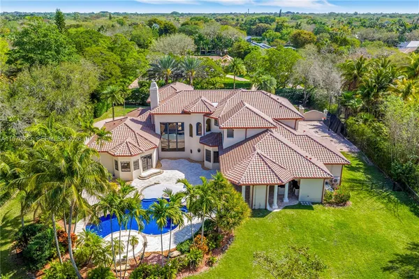 an aerial view of a house with yard swimming pool and outdoor seating