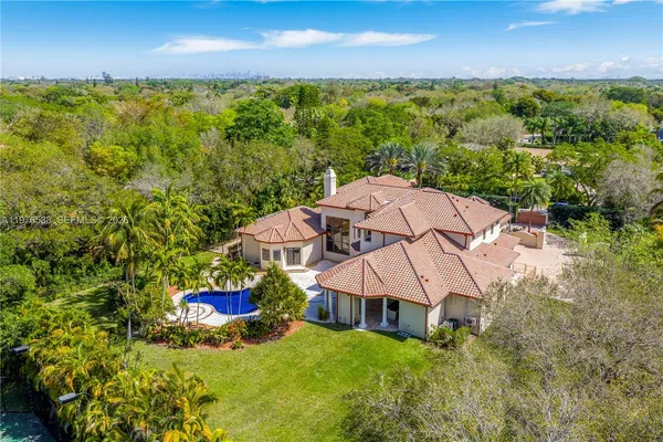 an aerial view of a house with a yard and lake view