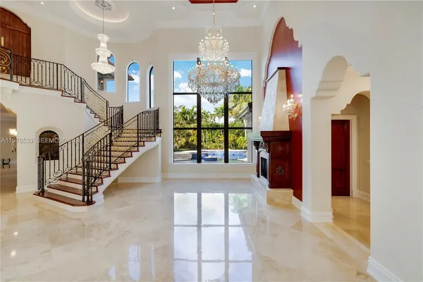 a view of a hallway with windows and chandelier