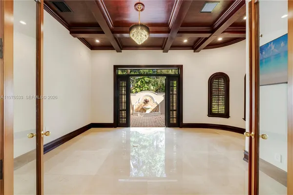 a view of a big room with entryway chandelier and front door