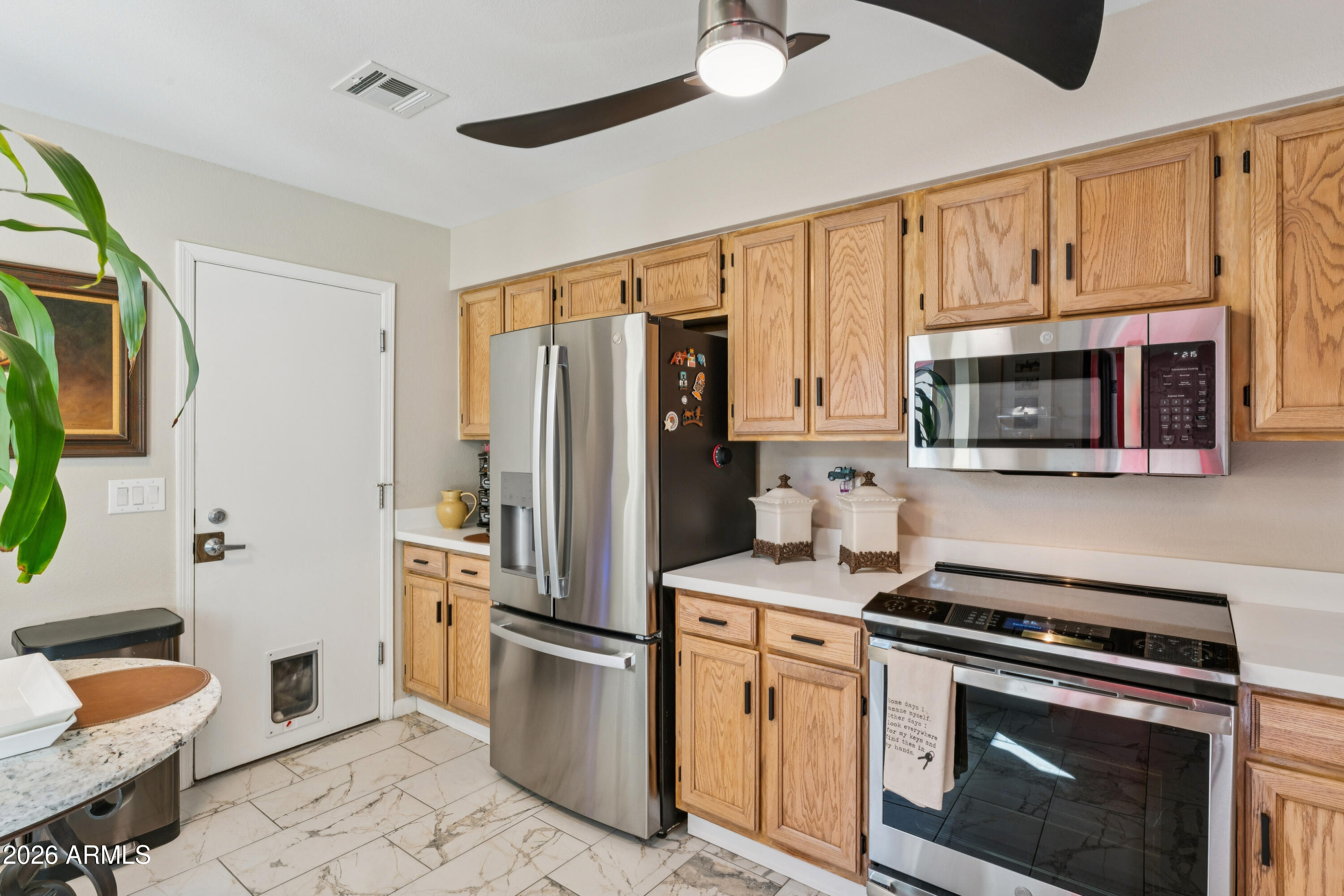 6027 South Alameda Road Gold Canyon, AZ 85118 - Photo 11 of 27 a kitchen with stainless steel appliances a stove a microwave and a refrigerator