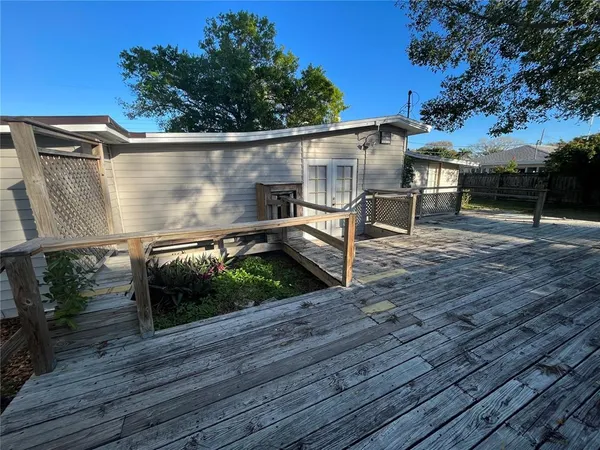 a backyard of a house with wooden floor table and chairs