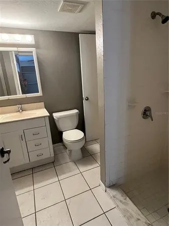 a bathroom with a toilet a sink a mirror and shower