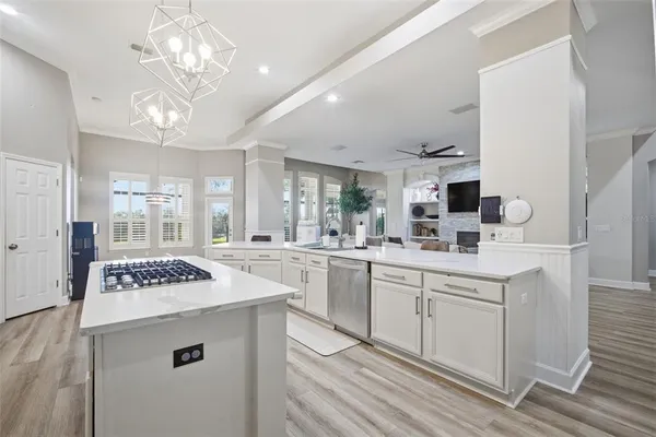 a kitchen with stainless steel appliances kitchen island granite countertop a sink and a stove top oven with wooden floor