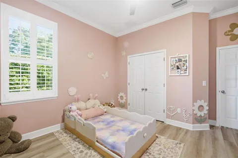 a bedroom with a bed and wooden floor